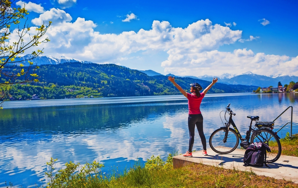 Frau mit E-Bike-Blick über den See-See und dem Fahrrad zu genießen 02