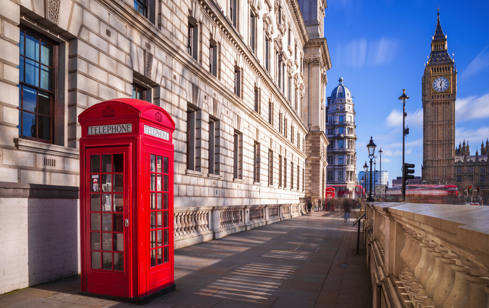 rote Telefonzelle mit Big Ben und Doppeldeckerbus im Hintergrund in London