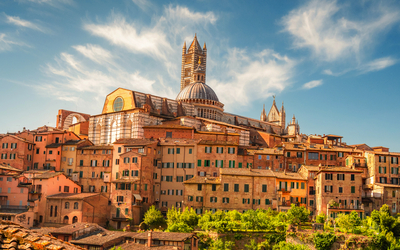Kathedrale von Siena mit umliegenden historischen Gebäuden bei klarem Himmel.