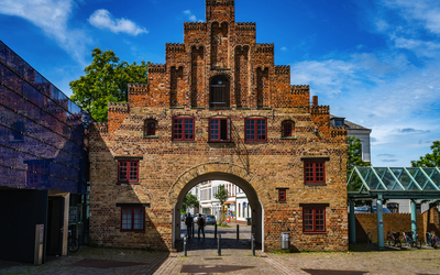 Backsteintor mit rotem Ziegelmuster und blauem Himmel im Hintergrund.