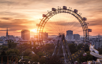 Blick über den Wiener Prater mit dem Riesenrad bei Sonnenuntergang im Hintergrund.