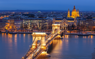 Stadtansicht bei Nacht mit beleuchteter Brücke und Kirche im Hintergrund