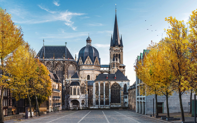 Kirche mit gotischer Architektur und herbstlichen Bäumen im Vordergrund