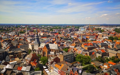 Blick auf eine europäische Stadt mit vielen roten Ziegeldächern und einer Kirche.