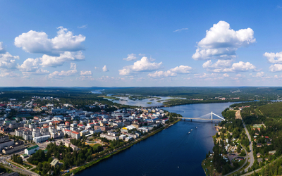 Stadtansicht mit Fluss und Brücke aus der Luft am Tag unter blauem Himmel.