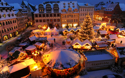 Weihnachtsmarkt in Naumburg mit Ständen und einem großen Weihnachtsbaum im Schnee.