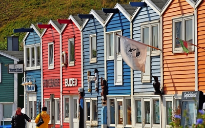 Bunte Häuserzeile mit Personen im Vordergrund.