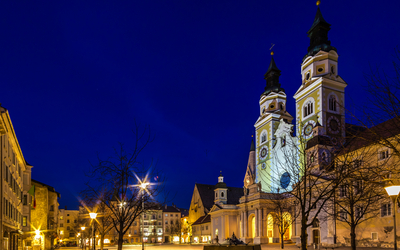 Nachtansicht des beleuchteten Brixner Doms im Winter auf dem Domplatz in Brixen, Trentino-Südtirol.