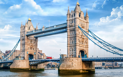 Tower Bridge in London mit einem roten Doppeldeckerbus auf der Brücke.