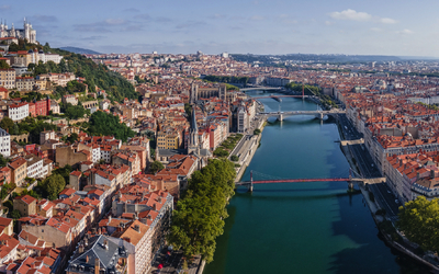 Panorama einer Stadt mit Fluss, darauf mehrere Brücken und historische Gebäude.
