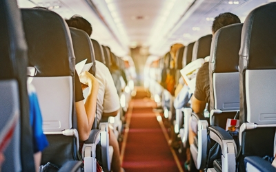 Passagiere sitzen in einer Flugzeugkabine.