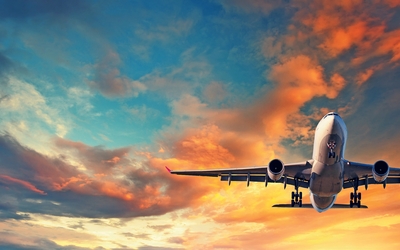 Flugzeug fliegt in den Sonnenuntergangshimmel.