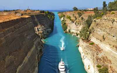 Ein Schiff fährt durch einen schmalen Kanal zwischen hohen Felswänden.