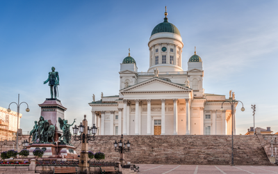 Helsinki Kathedrale bei klarem Himmel, im Vordergrund eine Statue und ein großer Platz.