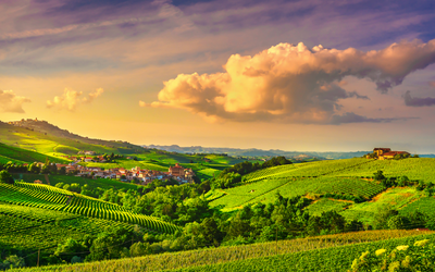 Hügelige Landschaft bei Sonnenuntergang mit Wolken am Himmel